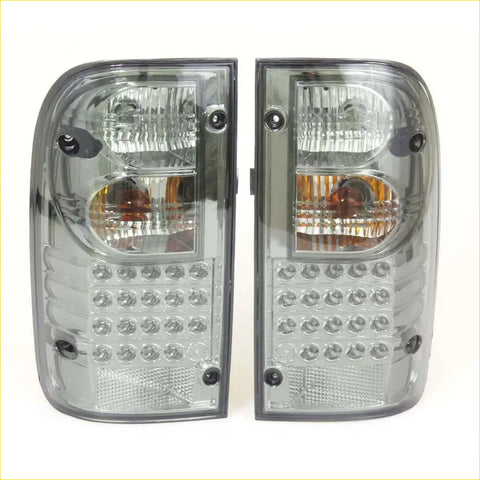 A pair of sleek smoked led tail lights with clear and amber lenses for toyota hilux mk4 mk5 1988-1997 back side view
