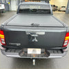 Black mitsubishi triton 2024 with manual roller shutter tonneau cover on the back of the pickup bed