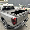 Back view of a gray ford ranger pickup truck with a black manual roller shutter tonneau cover for volkswagen amarok 2023+