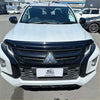 White mitsubishi triton pickup with black front grille and chrome emblem featuring monsoon bonnet guard 2019-2023