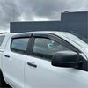 Black plastic window visors installed on a white mazda bt-50 pickup truck monsoon and bonnet guard 2012-2020