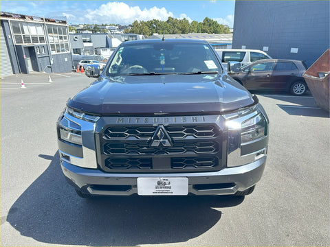 Dark gray metallic mitsubishi triton with bold chrome grille and led headlights featuring monsoon bonnet guard 2024 plus