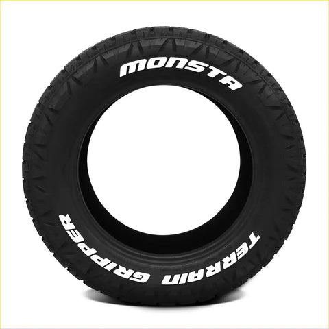 Black rubber monsta terrain gripper at tire 265 50 r20 with aggressive tread and white sidewall lettering