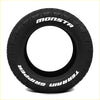 Black rubber monsta terrain gripper at tire 265 70 r17 with aggressive tread and white lettering on sidewall