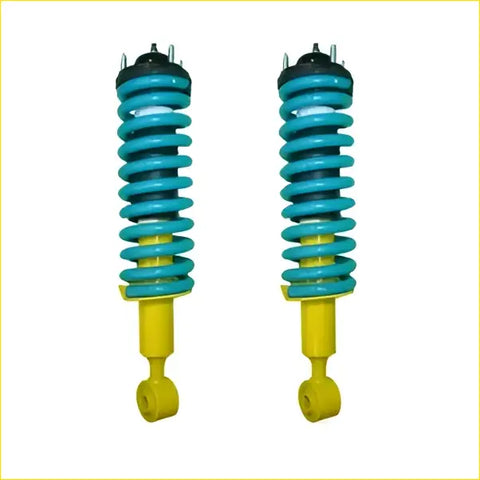 A pair of vibrant teal and yellow coil-over shock absorbers with black top mounts for nissan navara frontier d40