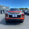 Vibrant red mitsubishi triton pickup with black q1 nudge bar featuring bold chrome grille and sleek led headlights