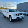 White nissan navara d40 pickup with black nudge bar lower style and roof rack, front view, thai model 2005-2015