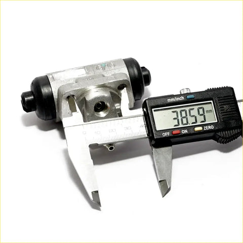 Rear wheel brake cylinder for nissan bluebird 1983-1992 silver and black metal drum with digital caliper measuring 38.59 mm