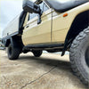 Beige toyota land cruiser 70 with black side steps and rugged tires featuring redback performance headers and exhaust