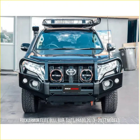 Black rockarmor elite steel bullbar with integrated headlights and toyota emblem fitted to 4wd prado fj150 ute