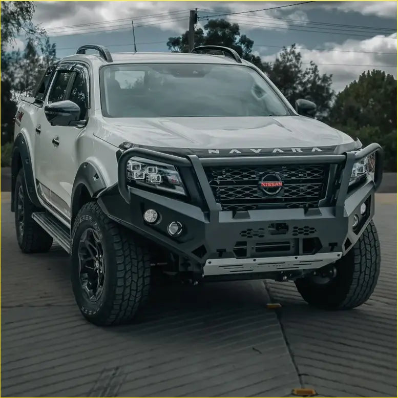 White nissan navara ute with black offroad rockarmor gt hoop bullbar combo pack and rugged 4wd tires