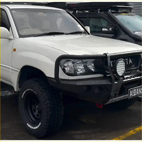 White toyota land cruiser with black steel rockarmor gt hoop bullbar and off-road tires for 105 series 98-07