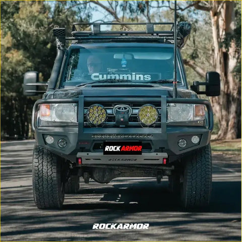 Black Toyota Land Cruiser with a steel Rockarmor GT hoop bullbar and dual circular LED lights front bumper installed