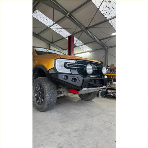 Black rugged steel rockarmor gt hoopless bullbar with led lights and red tow hooks on yellow ford ranger ute for 4wd offroad