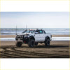 White ford ranger ute with black steel rockarmor gt hoop bullbar combo pack and large offroad tires on sandy beach