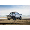 Silver toyota hilux pickup with black off-road rockarmor rock pack bullbar and rock sliders shown from the back side