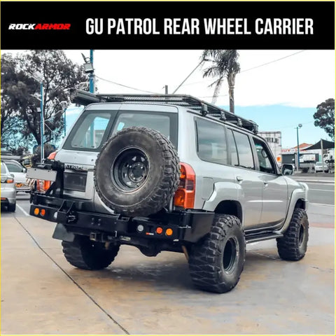 Silver nissan patrol 4wd with black rockarmor steel dual wheel carrier on rear holding spare tire for offroad use