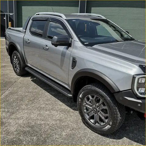 Silver ford ranger ute with black rockarmor steel rockslider side steps and rugged tires for offroad 4wd use