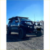 Black nissan navara pickup with silver bumper and roof rack featuring rockarmor steel rockslider side steps for np300 d23 2015+