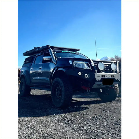 Black nissan navara pickup with silver bumper and roof rack featuring rockarmor steel rockslider side steps for np300 d23 2015+