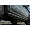 Black metal steel rockslider side steps with small red and white logo mounted on lower edge of gray nissan navara np300 d23