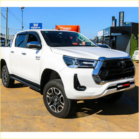 White toyota hilux ute with black grille and rockarmor steel rockslider side steps for offroad 4wd n90 2026+