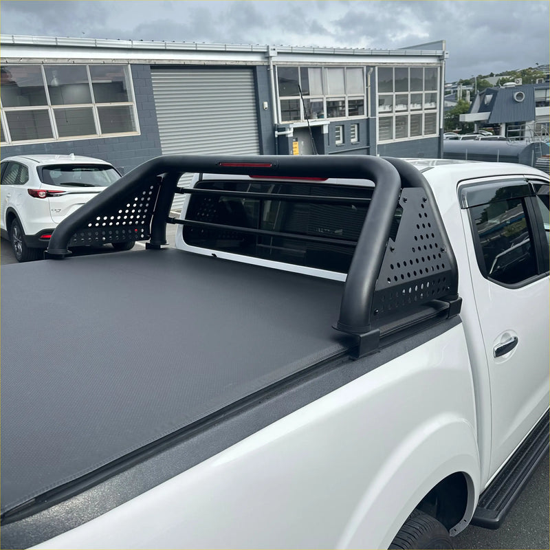 Black perforated steel truck bed rack with integrated side rails on white nissan navara 2021 back view