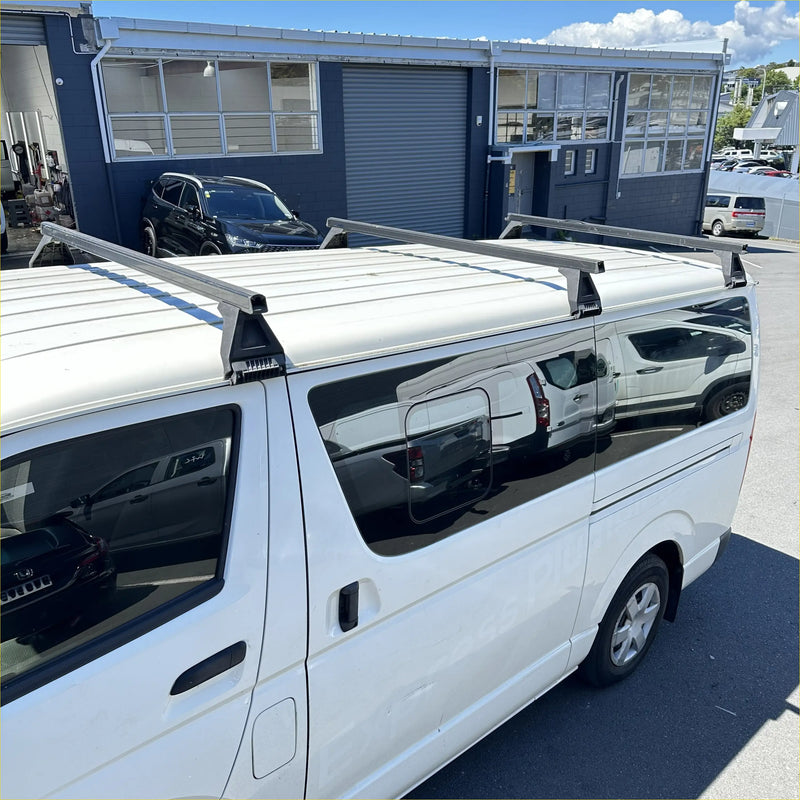 Silver aluminum heavy duty roof rack 3 piece set mounted on the back of white toyota hiace van narrow model
