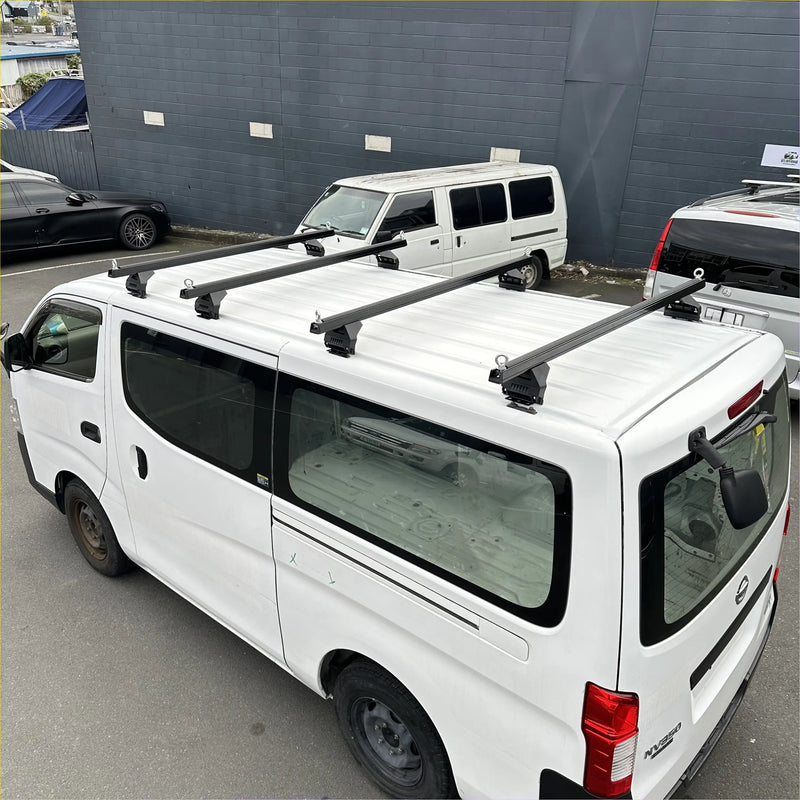 Black heavy duty roof rack 4 piece set mounted on white nissan nv350 caravan 2012-current backside view
