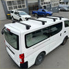 Black heavy duty roof rack 4 piece set mounted on the back side of white nissan nv350 caravan van