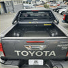 Back view of black toyota hilux srs limited with rugged manual roller shutter tonneau cover and chrome tailgate handle