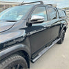 Black toyota hilux with black stainless steel 4 inch oval tube running boards and chrome side mirrors shown from side