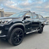 Black toyota hilux with glossy finish and black alloy wheels featuring stainless steel 4 inch oval tube running board