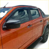 Black plastic window visors installed on an orange Mazda BT-50 pickup for weather protection 2012-2020 model