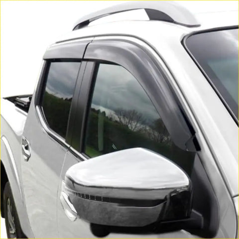 Black plastic window visors installed on a white toyota hilux vigo pickup for weather protection