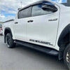 White toyota hilux double cab with black trim and srs cruiser decals showing oem style side step running board