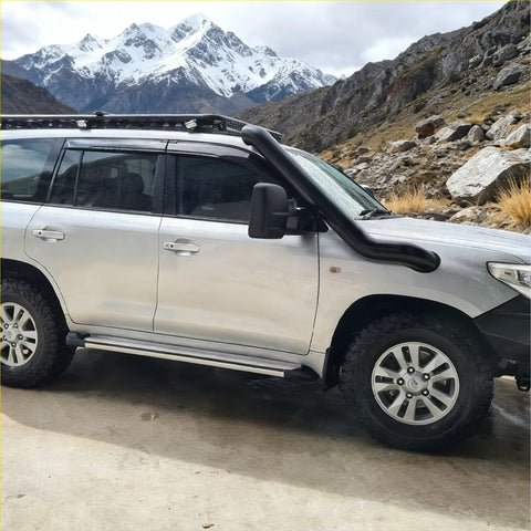 Silver toyota land cruiser 200 series 2017-2022 with black stainless steel snorkel and roof rack shown from the back side
