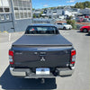 Dark gray mitsubishi triton pickup with black soft tonneau cover shown from the back side for 2024+ double cab