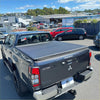 Back view of black mitsubishi triton 2024+ double cab with textured soft tonneau cover for pickup truck bed