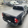 Black toyota hilux pickup with gray soft tonneau cover on the bed shown from the back side for 2015-2020 sr5 models