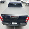 Dark blue toyota hilux 2015-2020 sr5 with gray hard-shell soft tonneau cover shown from the back side