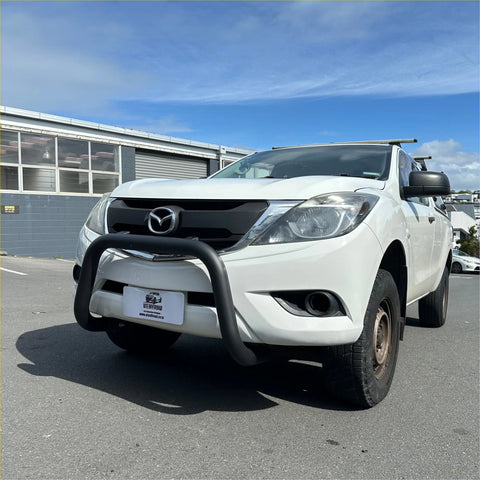 White mazda bt-50 pickup with a matte black stainless steel nudge bar and black front bumper guard visible from the front
