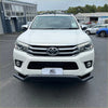 White toyota hilux pickup with chrome grille and black front bumper shown with stainless steel black nudge bar
