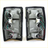 Black plastic tail light assemblies with chrome edges showing wiring and mounts for mazda b2000 1985-1998 back side