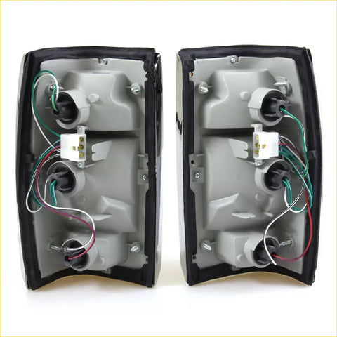 Black plastic tail light assemblies with chrome edge showing wiring and mounting for Mazda B2000 B2200 B2600 back side