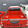 Back view of red toyota hilux 2021 pickup with textured black tailgate cover and glossy finish black trim