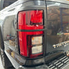 Black plastic tailgate light with red and clear lenses for mitsubishi triton 2024 matte black taillight covers back view