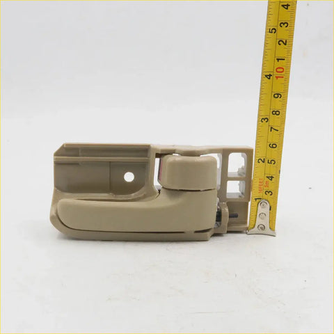 Tan plastic door handle pull with integrated latch mechanism for toyota hilux mk6 sr5 2004-2016 shown from back side