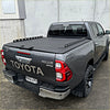 Dark gray toyota hilux sr5 double cab with black tomahawk aluminium hardlid and rugged off-road tires back view