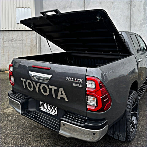 Black toyota hilux srs double cab with a lifted tomahawk aluminium hardlid bed cover shown from the back side